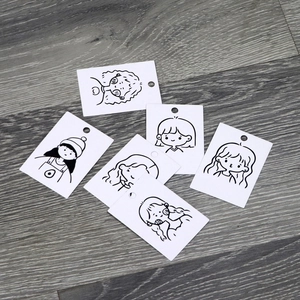 Detail of white earring display cards with cute black girl sketches and hanging holes