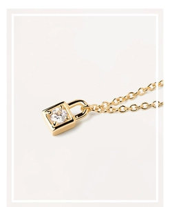 Macro shot of gold padlock necklace pendant with sparkling round-cut center zircon