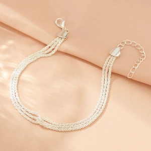 Detail of silver multi-layer chain necklace with lobster clasp on pink satin background