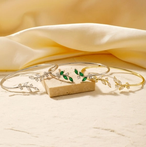 Close-up of willow leaf bangles in gold and silver finish with marquise cut gemstones