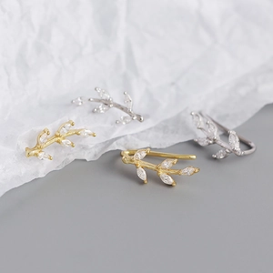Macro shot of silver and gold olive branch ear cuffs with marquise-cut marquise crystals