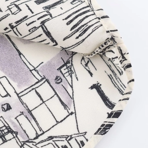 Macro detail of hand-drawn architectural print and neat stitching on casual shirt fabric