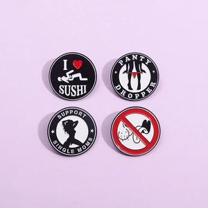Detailed view of four round enamel metal pins with humorous and graphic graphic designs