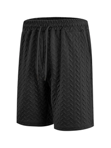 Close-up of black shorts showing the detailed 3D herringbone fabric texture and drawstring