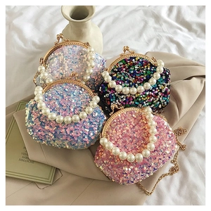 Detail of sequin shell bag featuring pearl handle and metallic clasp in four colors