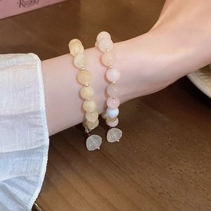 Detailed macro view of beaded bracelets with freshwater pearls and flower charms