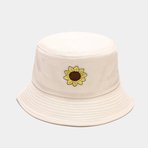 Dettaglio di una toppa ricamata con girasole su un cappello alla pescatora color crema
