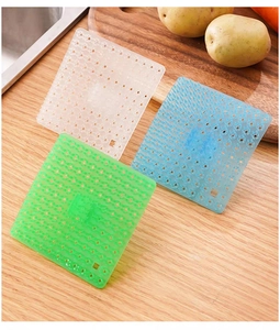 Tre tappetini scolapiatti quadrati in plastica blu verde e trasparente su legno