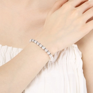 Gros plan d'un bracelet en perles avec billes argentées sur le poignet