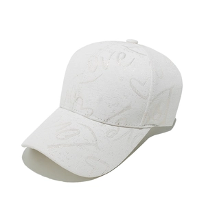 Détail d'une casquette blanche avec lettres LOVE scintillantes et motif cœur brodé