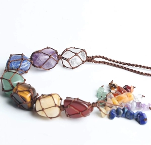 Detail of handcrafted chakra crystals with raw stones and woven rope for healing decor