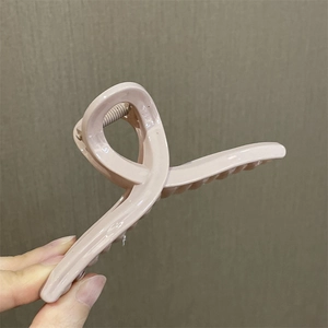 Vista macro de la pinza para el cabello retorcida rosa claro en material acrílico