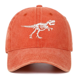 Close-up of dinosaur skeleton embroidery on a vintage washed orange cotton baseball cap