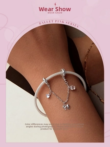 Detail of s925 silver mesh bracelet featuring bowknot and moonstone charms on wrist