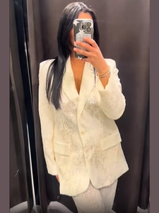 Dettaglio del tessuto con paillettes e del risvolto del blazer beige da donna