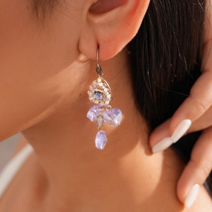 Close-up of a model wearing vintage purple teardrop crystal earrings with silver hooks