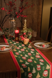 Detail of Christmas table runner with jacquard Santa Claus and tree patterns in green