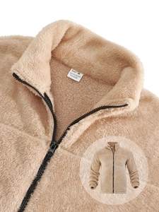 Detail of beige fleece jacket showing soft texture and polyester blend collar tag