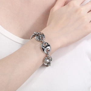 Dettaglio macro del bracciale a maglie chicco di caffè argento sul polso