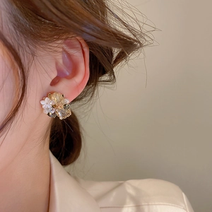 Detail of vintage flower earrings with crystal and mother of pearl on a female model