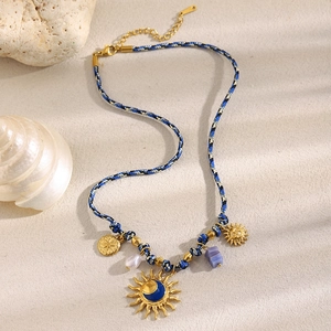 Detail of 18K gold sun and moon pendants on a blue-black woven rope necklace