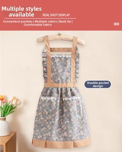 Gros plan du tablier en toile fleurie avec bordures en dentelle et doubles poches