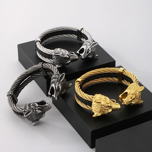 Detail showing braided steel wire and leather cord textures with wolf head terminals