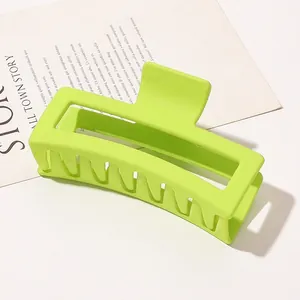 Detail view of large neon green matte shark hair claw clip with strong metal spring