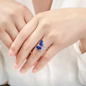 Elegant silver open ring with pear-shaped blue sapphires and butterfly wing design
