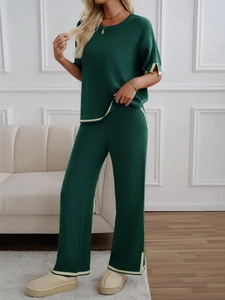 Detail showing dark green knit two-piece set with white contrast piping on wide-leg pants