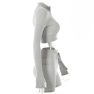 Detail view of light grey ribbed knit long sleeve crop top and high waist yoga shorts