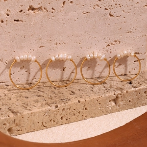 Close-up of gold 18K plated rings with small freshwater pearls on a natural stone