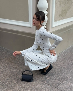 Detail of white polka dot maxi dress featuring slim fit long sleeves and round neckline