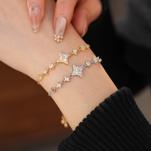 Detailed view of gold and silver star bracelets with shimmering cubic zirconia stones