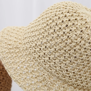 Close-up of the breathable hollow knit texture on a beige summer straw bucket sun hat