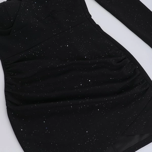 Primer plano de tela negra fruncida con lentejuelas plateadas brillantes y textura