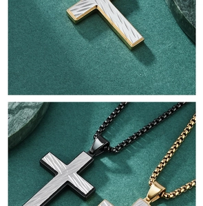 Detailed view of black and gold cross pendants with textured patterns for men