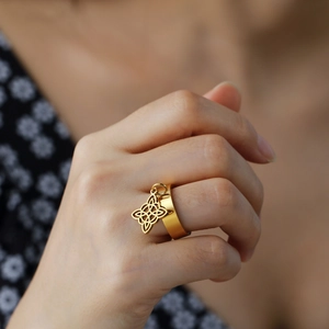 Gold stainless steel wide ring with Celtic Knot pendant worn on finger