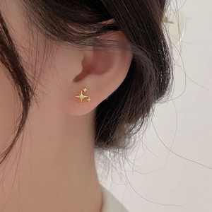 Elegant 925 sterling silver gold star stud earring worn on model for minimalist style