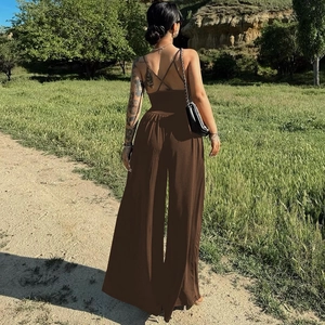 Detail showing the backless design with crisscross straps on a brown wide-leg jumpsuit