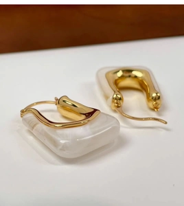 Detail of 18K gold-plated U-shaped earrings with marbled white resin rectangles