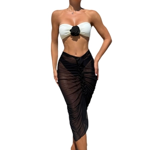 Three-piece bikini set with white rose bandeau top and sheer black mesh long skirt