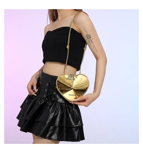 Detail einer goldenen herzförmigen Umhängetasche mit FASHION & BAGS Aufschrift