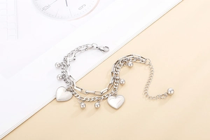 Detailed shot of double-layered silver heart bracelet with beads and lobster clasp