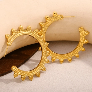 Macro view of C-shaped 18K gold plated earrings with wheat pattern and bead texture