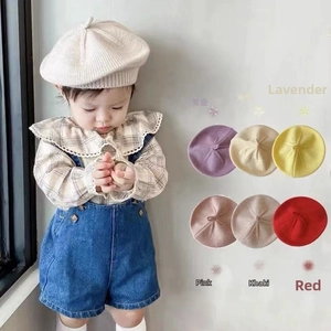 Vue détaillée montrant sept couleurs de bérets en tricot de coton pour bébés et enfants