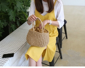 Handmade straw bucket bag with drawstring liner and dual handles for summer vacations