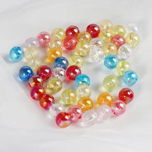 Colorful round acrylic beads for DIY jewelry making on white mesh fabric background