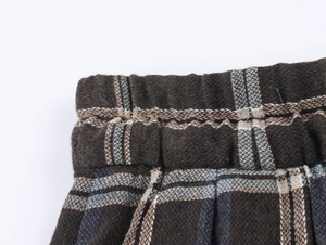 Detailaufnahme des elastischen Bundes der dunkel karierten modischen Freizeithose