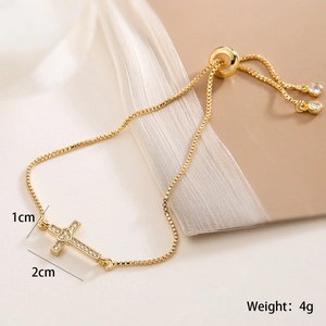 Detail of 18K gold plated cross bracelet with heart zircon and adjustable slider clasp